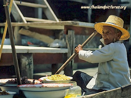 An old thai woman in her boat at the floating market